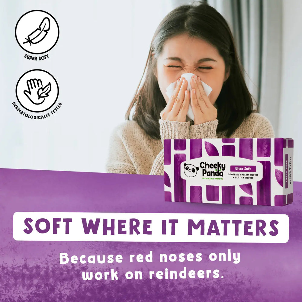Person using tissues with a box of Cheeky Panda balsam tissues on a purple background, emphasizing their softness