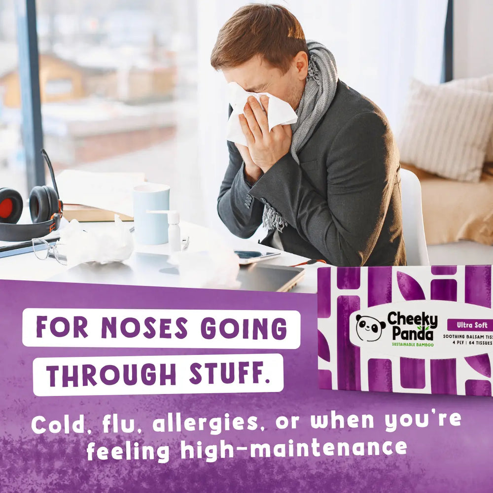 Person blowing their nose with a box of Cheeky Panda balsam tissues in the foreground