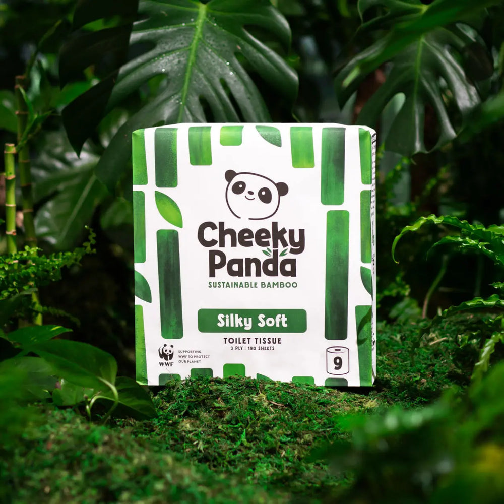 Cheeky Panda sustainable bamboo toilet paper pack in a natural setting with green leaves.