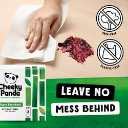Cheeky Panda kitchen towel packaging with a hand wiping up a spill on a beige surface.