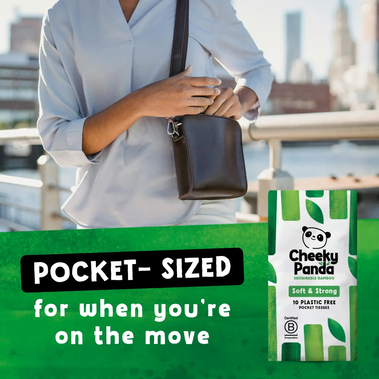 Person holding a brown leather bag with Cheeky Panda pocket-sized tissues packaging on a green background.