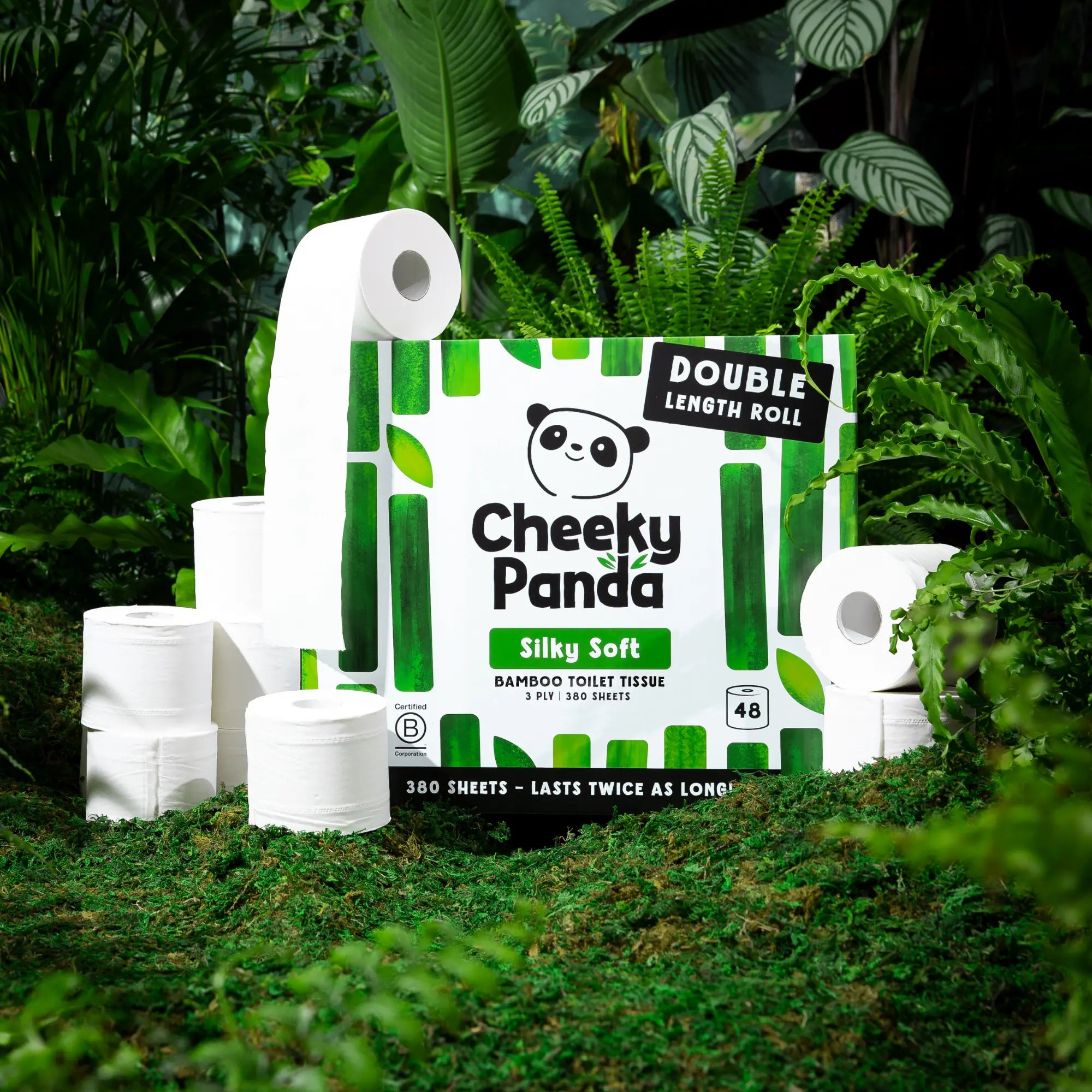 Cheeky Panda Silky Soft bamboo toilet tissue pack surrounded by rolls and lush green foliage.